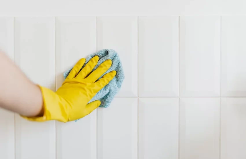 mulher limpando a parede para acabar com o mofo